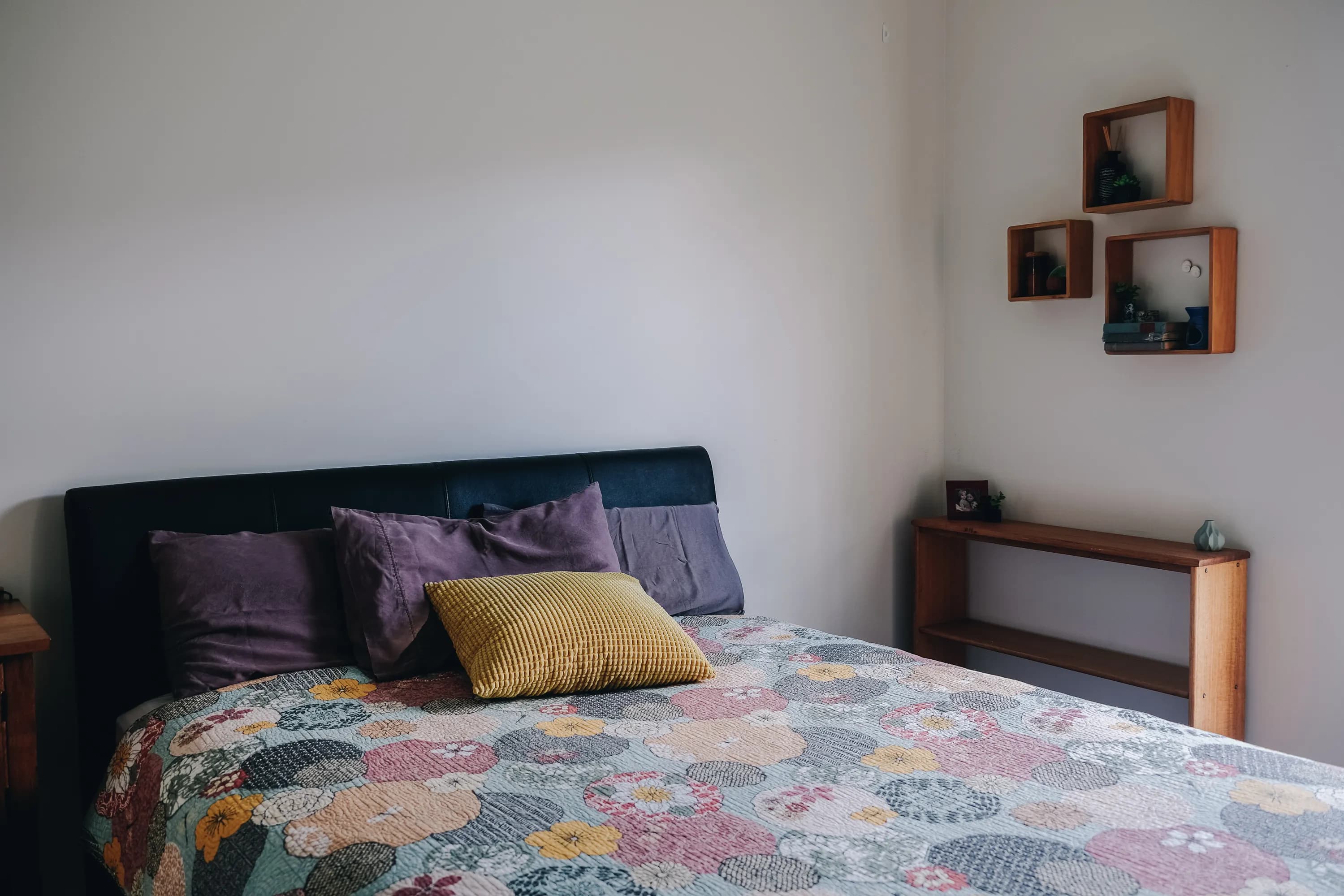 A neatly made bed with folded linen and morning light